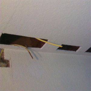 Cut holes in ceiling to drill joists