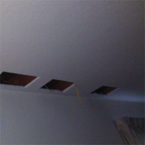 Cut holes in ceiling to drill joists